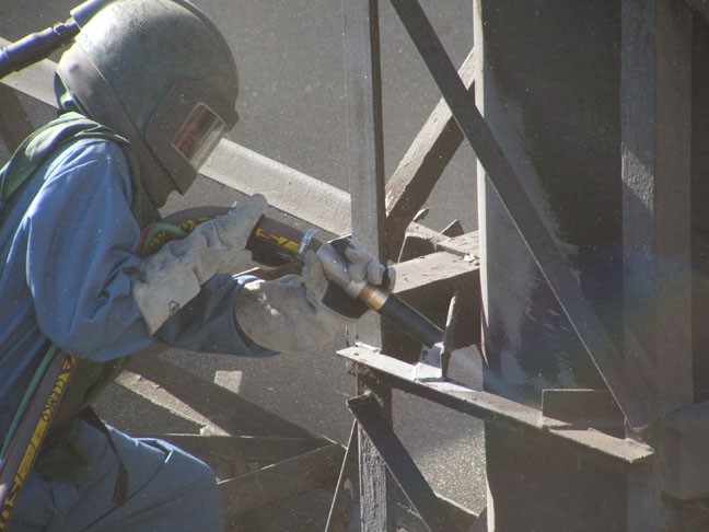 factory worker doing bead blasting surface finish